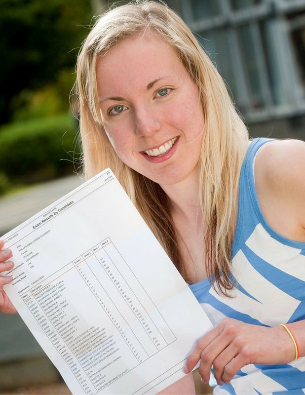 A young woman smiling to camera, holding out an exam transcript